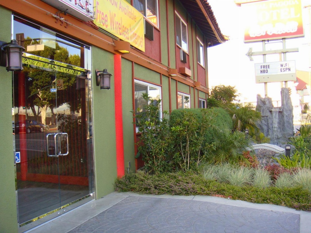 A green building with red trim and a glass door.