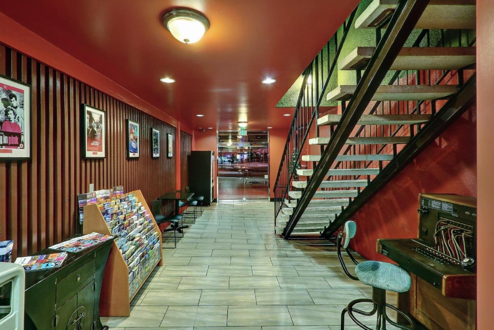 a hotel lobby with a red wall and a staircase