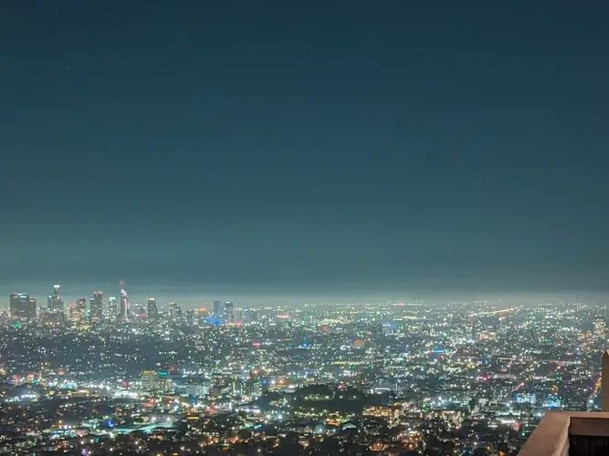 A nighttime cityscape view of a large city with many lights.